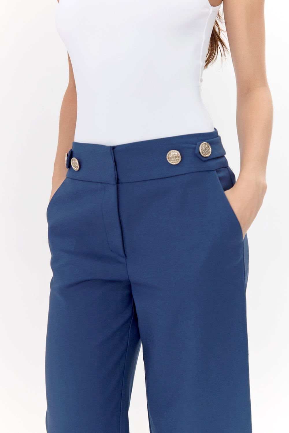 Close-up of navy trousers with model's hands in pockets.